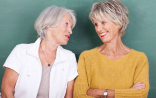 Two senior women smiling and chatting